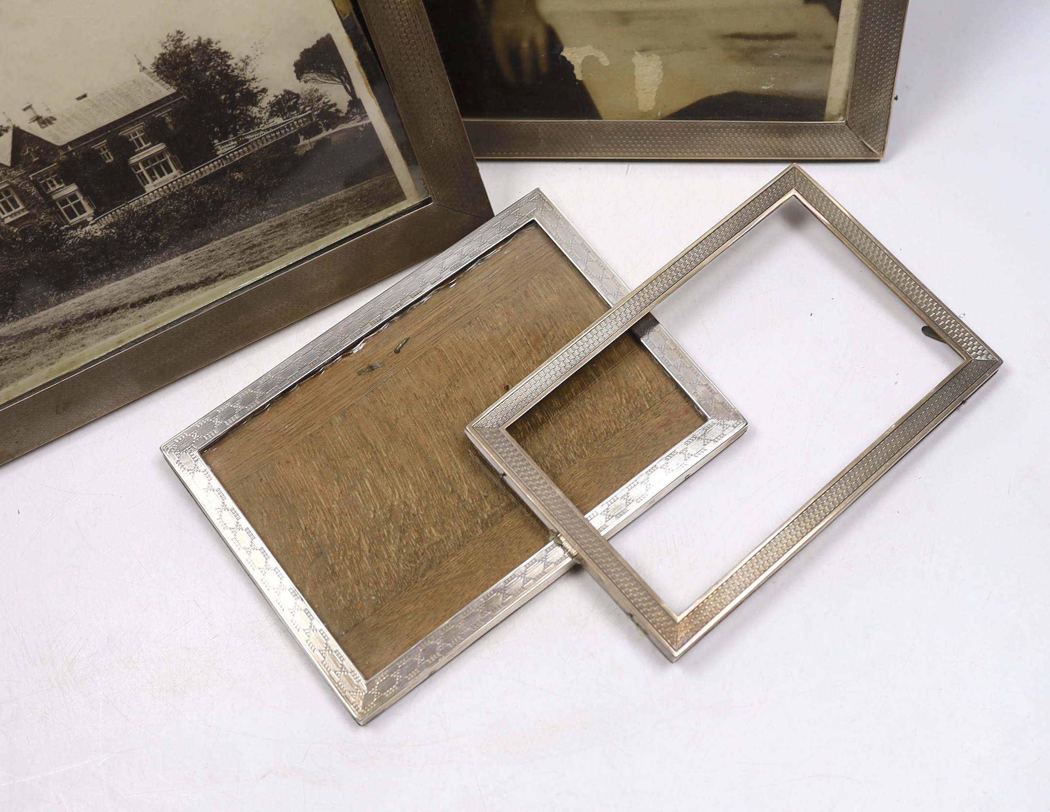Four assorted early to mid 20th century silver mounted rectangular photograph frames, largest 28.6cm.